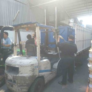 menurunkan mesin press dengan bantuan forklift