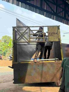 Menaikkan mesin screw conveyor ke atas truk 